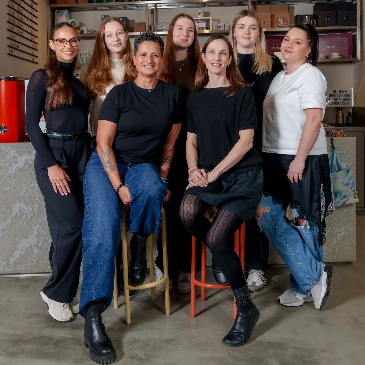 Tým Klubu Ambiente pózuje v interiéru obchodu s produkty a merchem.