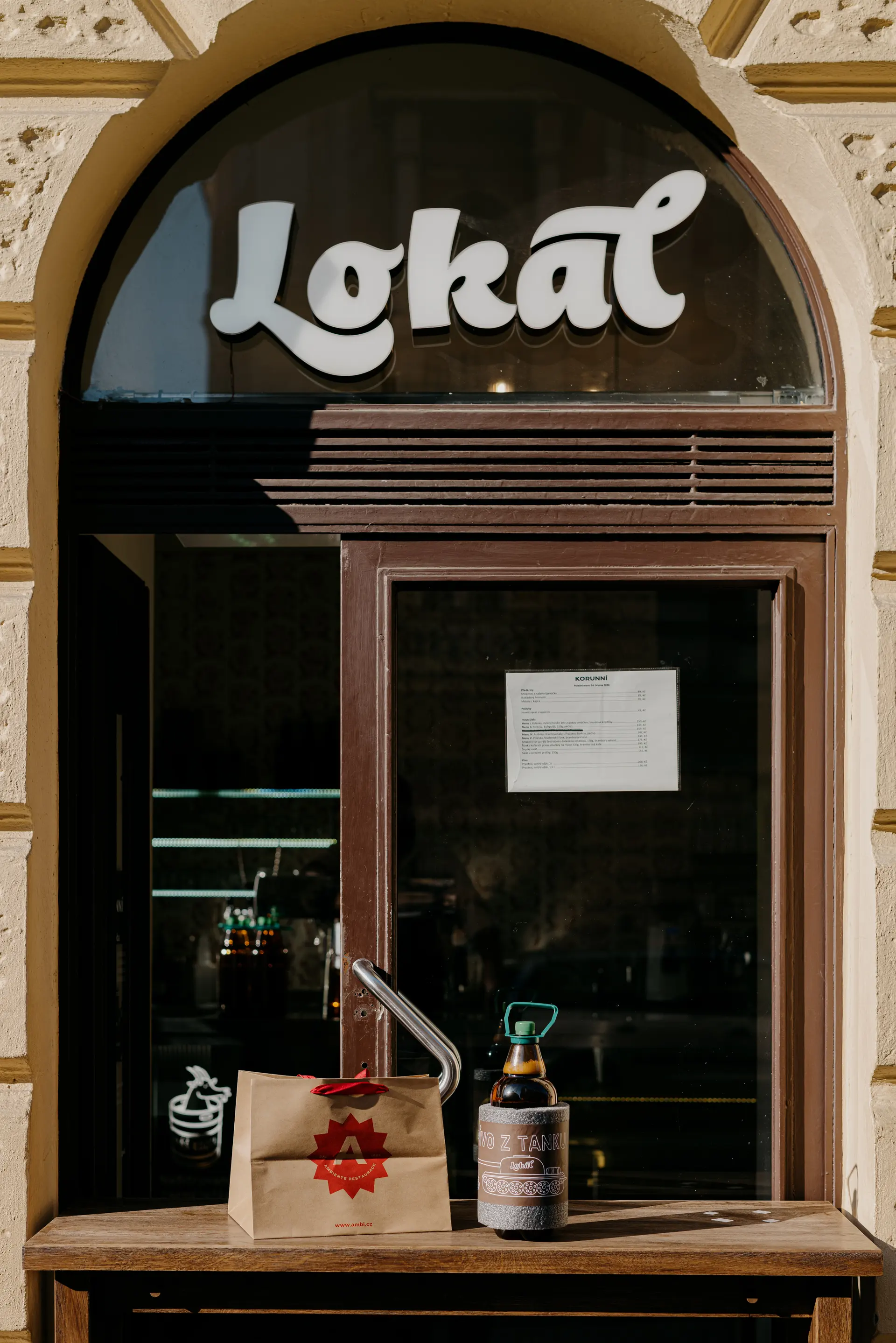 Dveře do restaurace Lokál s logem na dveřích.