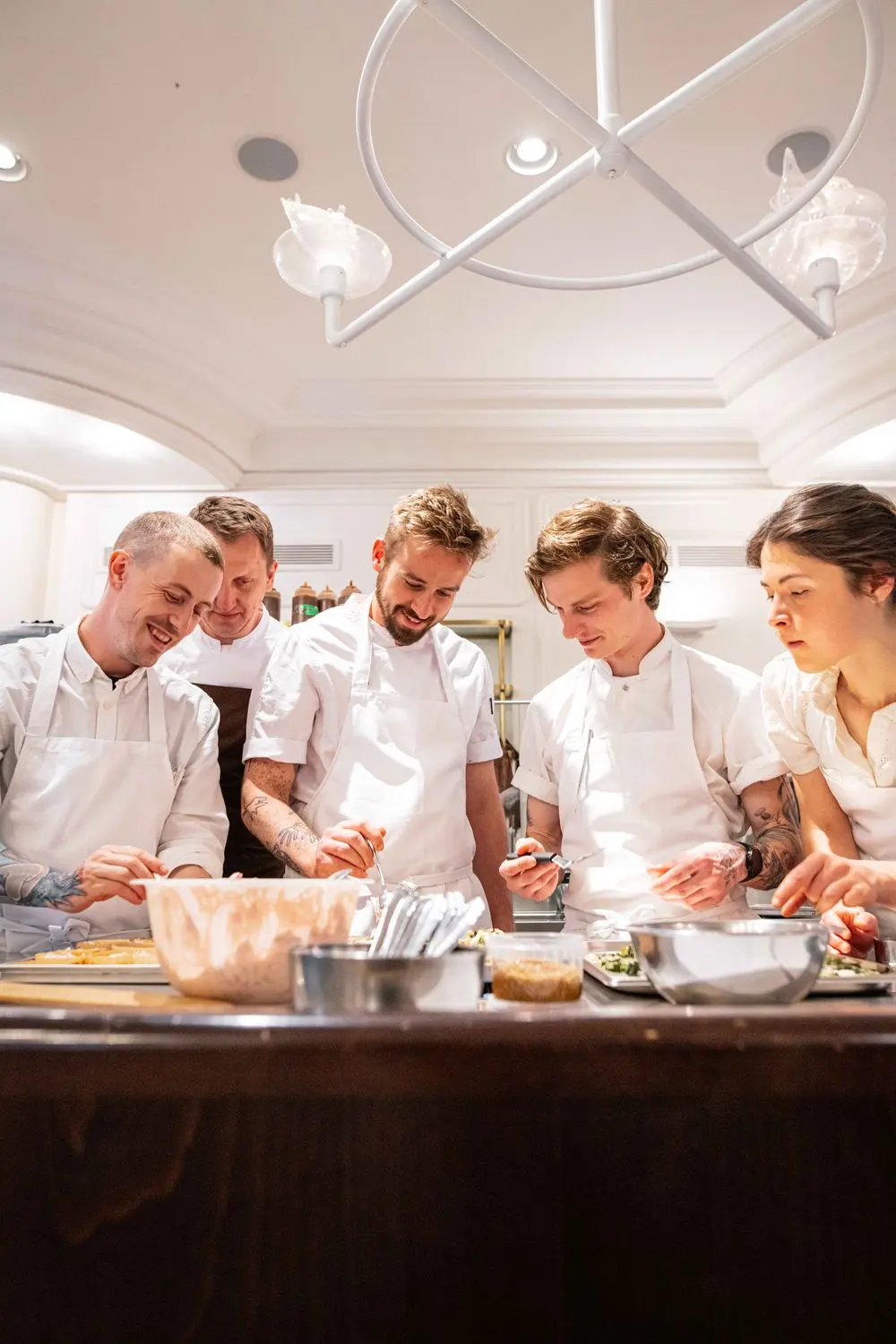 Team of chefs preparing food in a professional kitchen.