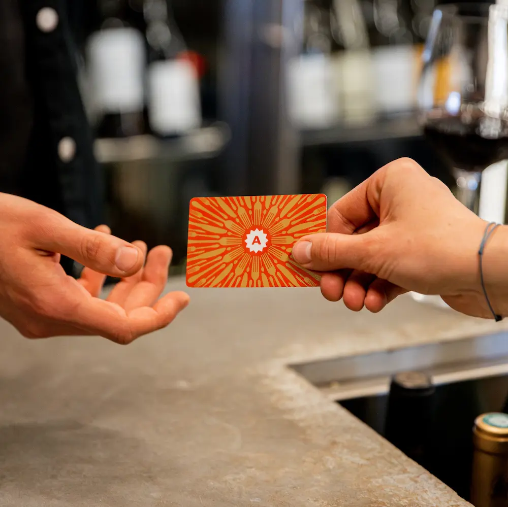 Handing over an Ambiente gift card at the bar in a restaurant.